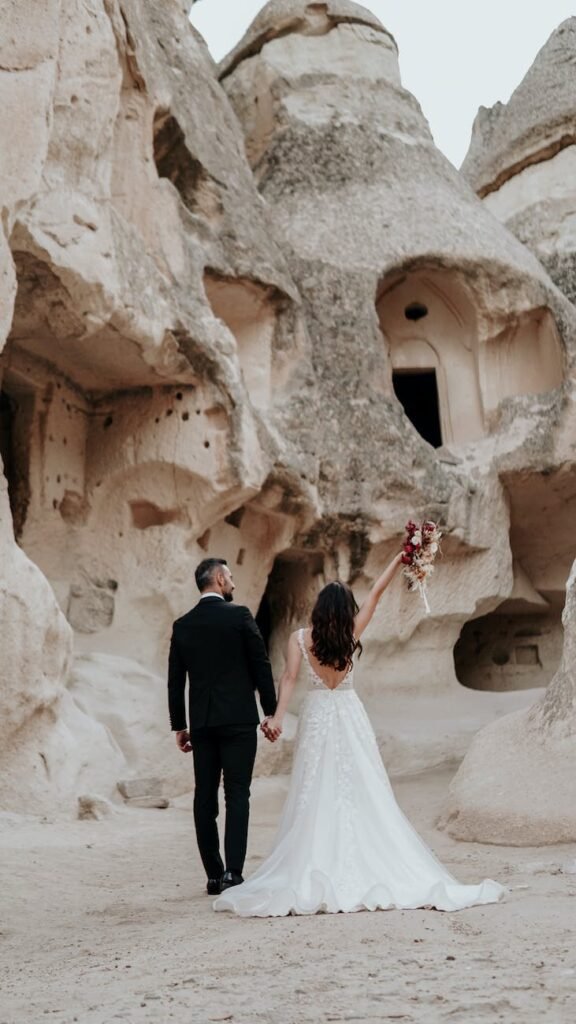 back view of a bride and a groom holding hands