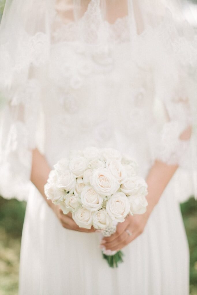 woman wearing white wedding gown while holding bouquet