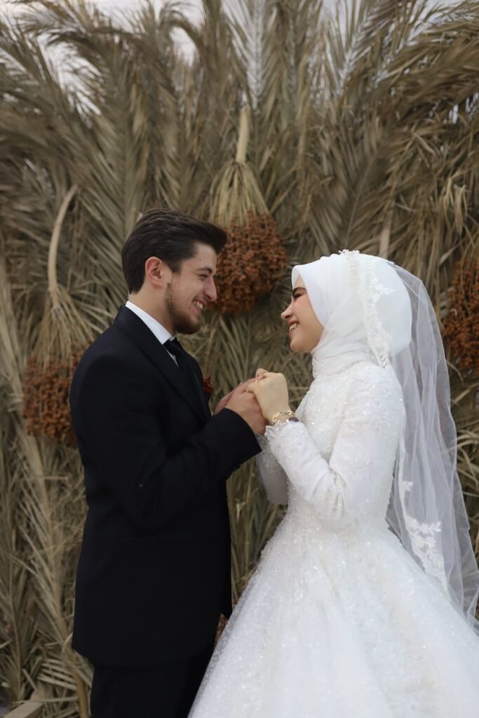 a bride and a groom smiling while looking at each other